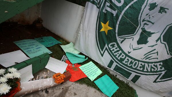 Цветы и флаг футбольного клуба Шапекоэнсе перед стадионом в бразильском городе Шапеко