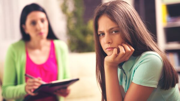 Профессиональный психолог работает с девочкой-подростком. Архивное фото