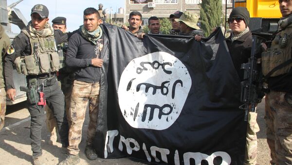 Бойцы Золотой дивизии фотографируются на фоне флага радикалов в Мосуле
