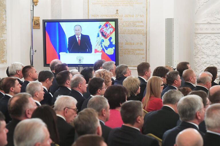 Экран с трансляцией выступления президента России Владимира Путина с ежегодным посланием Федеральному Собранию РФ в Георгиевском зале Кремля. 1 декабря 2016 Экран с трансляцией выступления президента России Владимира Путина с ежегодным посланием Федеральному Собранию РФ в Георгиевском зале Кремля. 1 декабря 2016