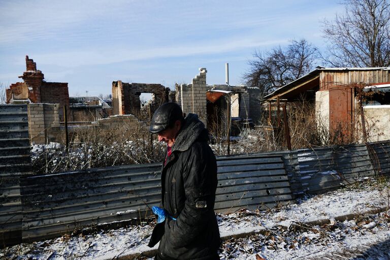 Мужчина на улице Взлётная в районе донецкого аэропорта, где проводятся восстановительные работы домов Мужчина на улице Взлётная в районе донецкого аэропорта, где проводятся восстановительные работы домов
