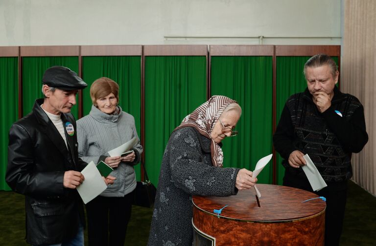 Женщина голосует на избирательном участке в Ташкенте во время выборов президента Узбекистана