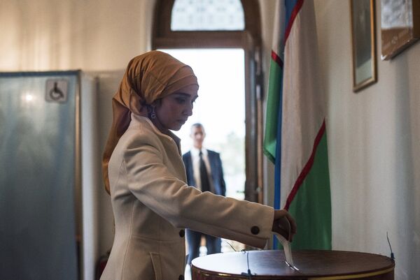 Женщина голосует на избирательном участке во время выборов президента Узбекистана