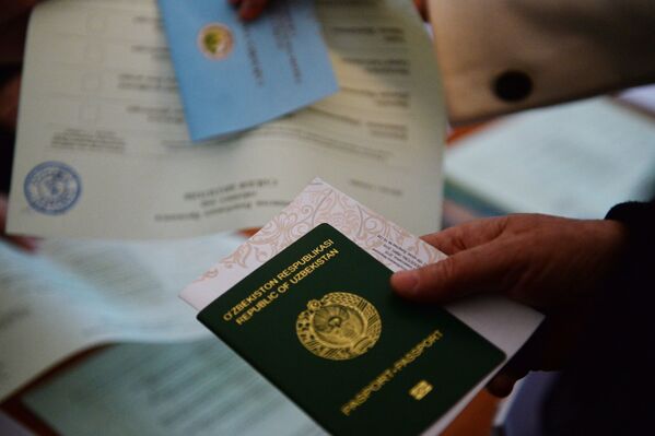 Паспорт и бланк в руках избирателя во время выборов президента Узбекистана