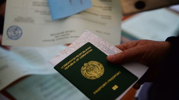 Паспорт и бланк в руках избирателя во время выборов президента Узбекистана