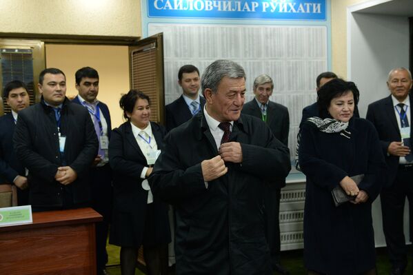 Лидер Социал-демократической партии Адолат (Справедливость) Наримон Умаров (в центре) голосует на избирательном участке во время выборов президента Узбекистана