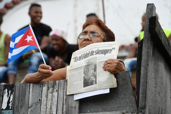 Женщина ожидает траурный кортеж с прахом команданте Фиделя Кастро в Сантьяго-де-Куба