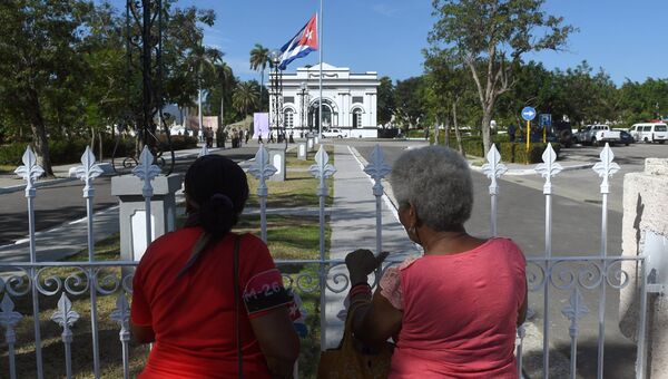 Жительницы города у входа на кладбище Санта-Ифигения в Сантьяго-де-Куба - место захоронения лидера кубинской революции Фиделя Кастро. 4 декабря 2016