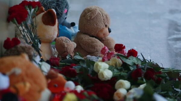 Цветы и игрушки у здания СДЮСШОР Сибиряк в Нефтеюганске в память о погибших в автокатастрофе на трассе Тюмень — Ханты-Мансийск