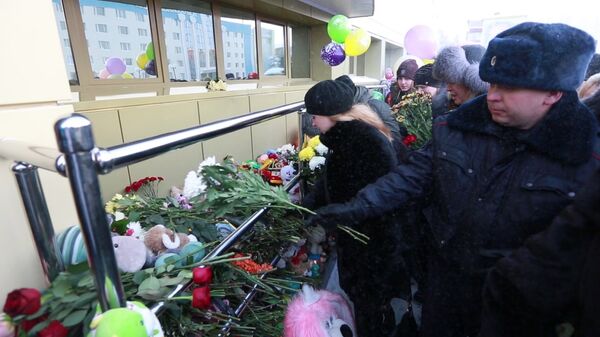 Жители несут цветы к зданию СДЮСШОР Сибиряк в Нефтеюганске в память о погибших в автокатастрофе на трассе Тюмень — Ханты-Мансийск