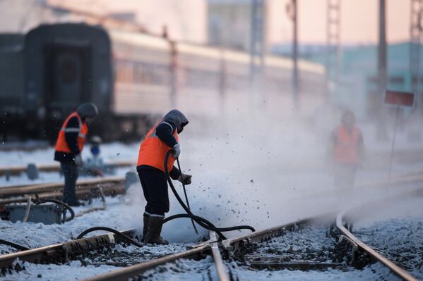 Рабочие очищают железнодорожный путь на станции Омск-Пассажирский