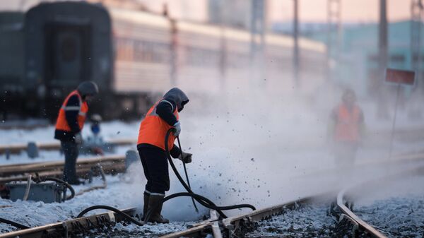 Рабочие очищают железнодорожный путь на станции Омск-Пассажирский