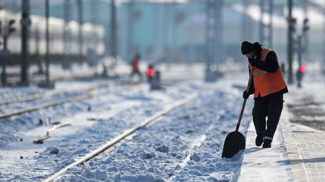 Рабочий очищает железнодорожный путь. Архивное фото