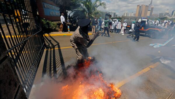 Кенийский полицейский во время акции протеста врачей, протестующих против низких зарплат и неудовлетворительных условий труда в Найроби