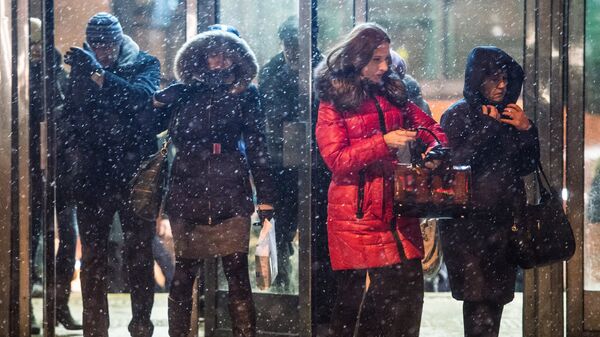 Люди выходят со станции метро Новокосино в Москве во время снегопада