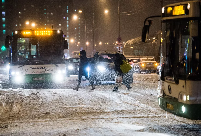 Прохожие переходят дорогу в Москве во время снегопада Прохожие переходят дорогу в Москве во время снегопада