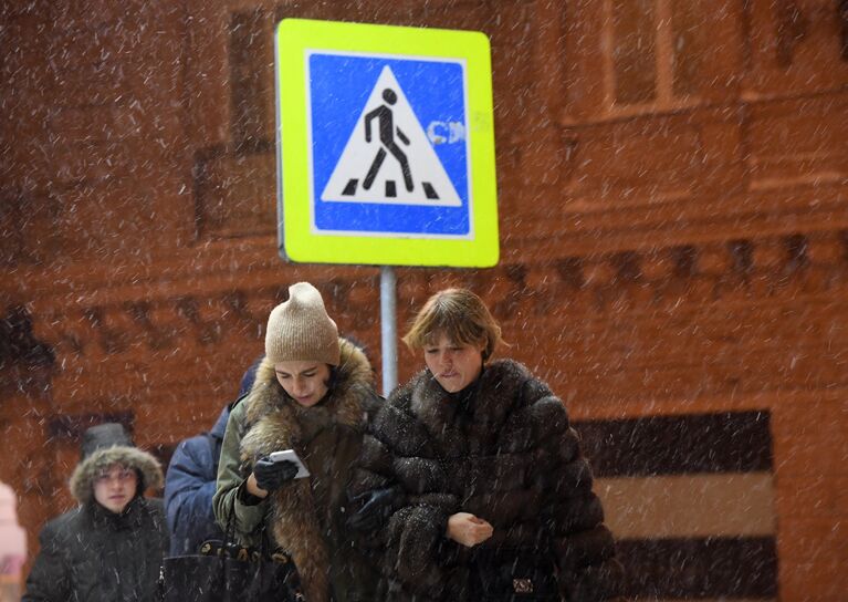 Прохожие в Москве во время снегопада