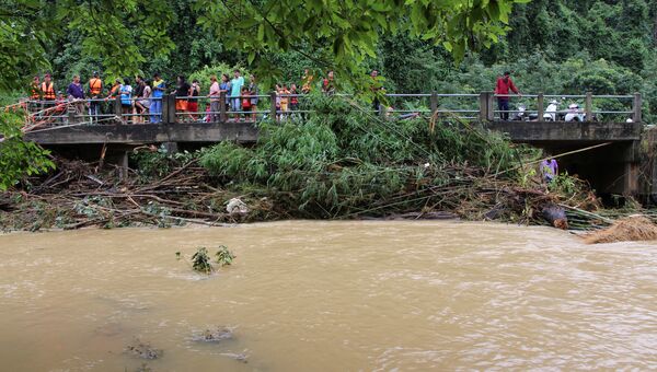 Люди на мосту во время наводнения в провинции Накхон Ситхаммарат, Таиланд