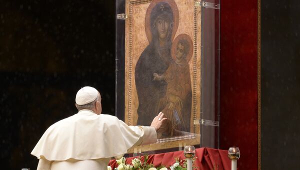 Папа римский Франциск касается иконы с ликом Девы Марии в Ватикане