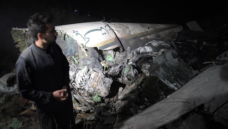 Местный житель на месте крушения самолета авиакомпании PIA недалеко от Абботтабада, Пакистан