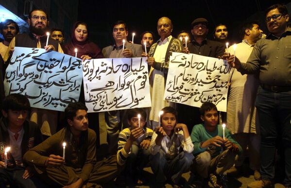 Люди держат свечи в память о жертвах авиакатастрофы самолета авиакомпании PIA в Мултане, Пакистан