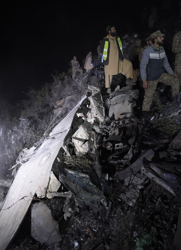 Пакистанские солдаты и волонтеры на месте крушения самолета авиакомпании PIA недалеко от Абботтабада, Пакистан