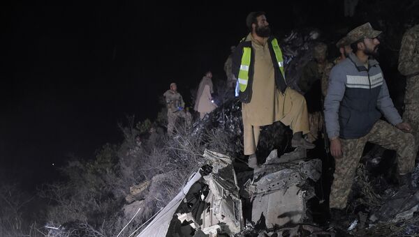 Пакистанские солдаты и волонтеры на месте крушения самолета авиакомпании PIA недалеко от Абботтабада, Пакистан