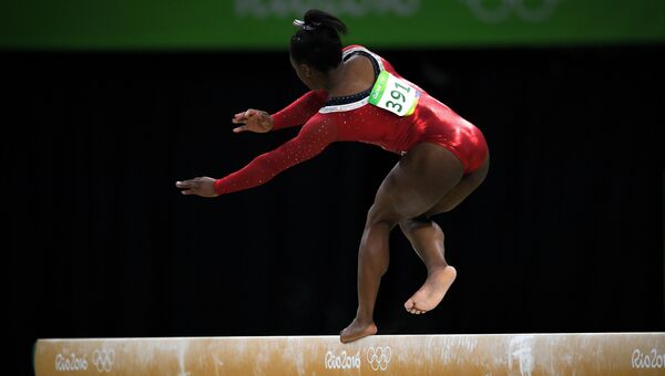 Симона Байлз (США) выполняет упражнения на бревне в финале соревнований по спортивной гимнастике среди женщин на XXXI летних Олимпийских играх