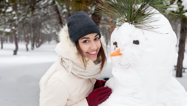 Девушка со снеговиком. Архивное фото