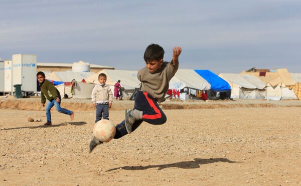 Иракские дети играют в мяч в лагере беженцев в Хазере, Ирак