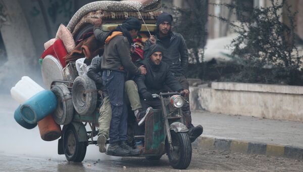 Мужчины перевозят вещи на трехколесном мотоцикле в Алеппо
