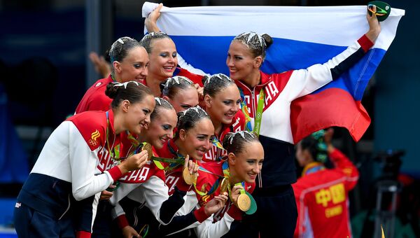 Спортсменки сборной России, завоевавшие золотые медали в произвольной программе групповых соревнований по синхронному плаванию на XXXI летних Олимпийских играх, на церемонии награждения. Архивное фото