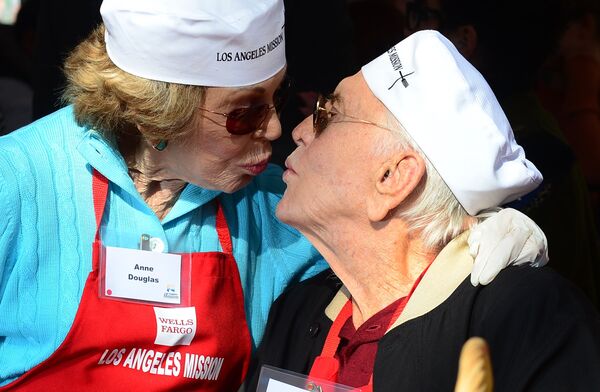 Актер Кирк Дуглас со своей женой Энн принимают участие в Праздничном благотворительном обеде для бездомных в день Благодарения в Лос-Анджелесе