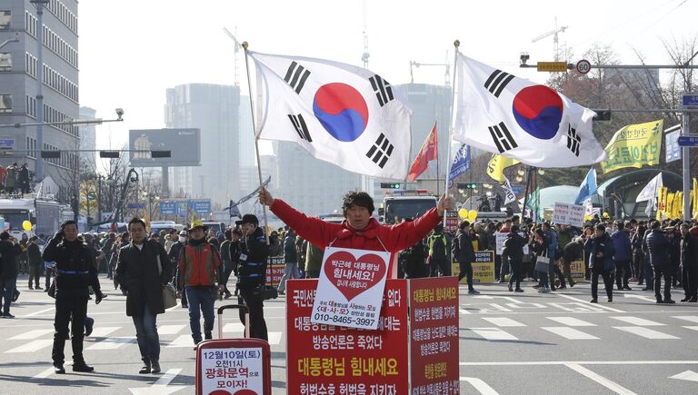 Сторонник президента Южной Кореи Пак Кын Хе на митинге возле здания Национального собрания в Сеуле