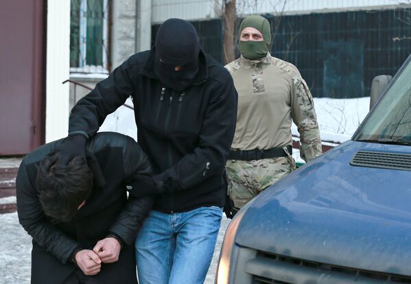 Силовики выводят из подъезда дома № 11 на улице Наметкина участника диверсионно-террористической группы, готовившей серию терактов в Москве