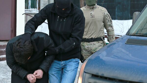 Силовики выводят из подъезда дома № 11 на улице Наметкина участника диверсионно-террористической группы, готовившей серию терактов в Москве