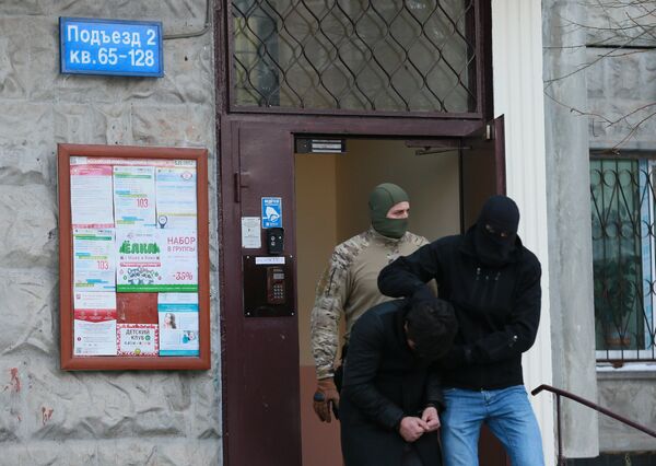 Силовики выводят из подъезда дома № 11 на улице Наметкина одного из участников диверсионно-террористической группы, готовившей серию терактов в Москве