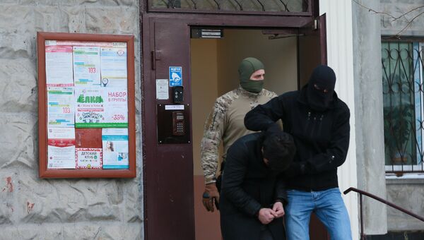 Силовики выводят из подъезда дома № 11 на улице Наметкина одного из участников диверсионно-террористической группы, готовившей серию терактов в Москве