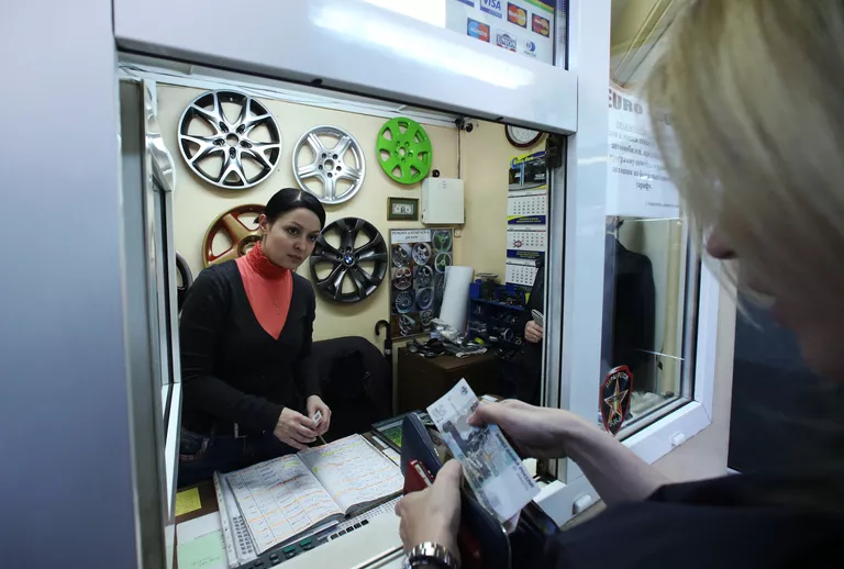 Автовладелец оплачивает услуги в кассе автосервиса Автовладелец оплачивает услуги в кассе автосервиса