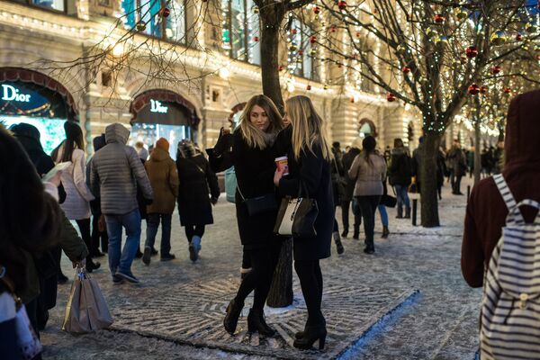 Девушки фотографируются на ГУМ-Ярмарке на Красной площади в Москве