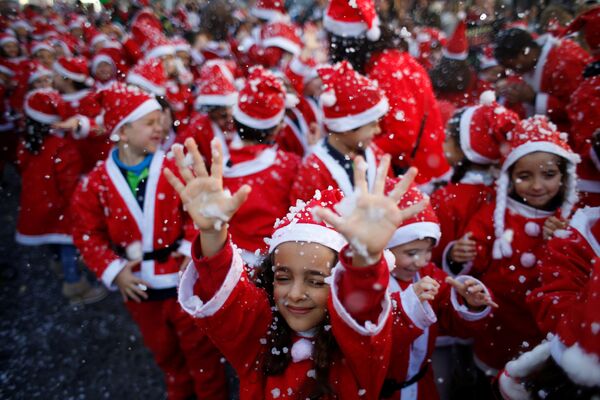 Дети, одетые как Санта-Клаус на параде, чтобы собрать еду для нуждающихся в Лиссабоне, Португалия. 12 декабря 2016