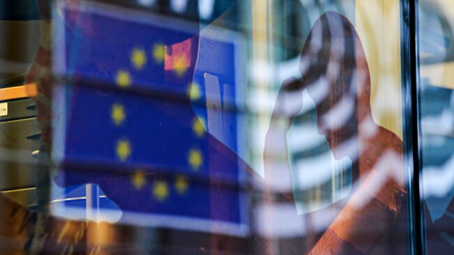 Отражение флага Евросоюза в окне одного из зданий в Брюсселе. Архивное фото