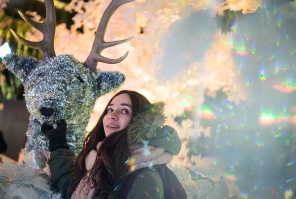 Девушка во время тестового включения световой новогодней инсталляции Музыкальный лес на Пушкинской площади в Москве