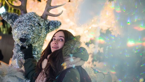 Девушка во время тестового включения световой новогодней инсталляции Музыкальный лес на Пушкинской площади в Москве