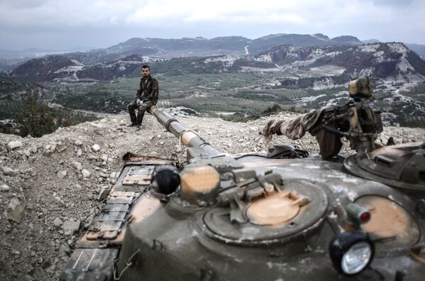 Танкисты правительственных войск сирийской армии на вершине холма в провинции Латакия рядом с турецкой границей