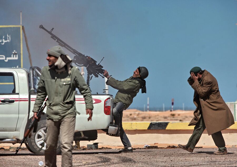 Боец оппозиции стреляет из пулемета в истребитель в городе Рас-эль-Ануф