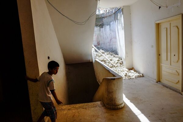 Мальчик из семьи сирийских беженцев в одном из домов в городе Хальба на севере Ливана