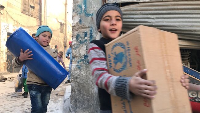 Дети, получившие гуманитарную помощь в квартале Алеппо. Архивное фото