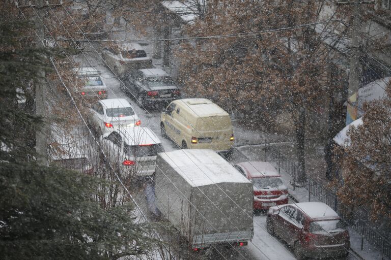 Дорожное движение на заснеженной улице Симферополя.