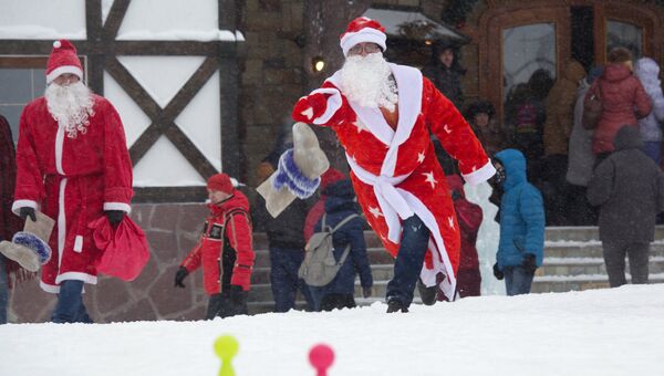 Участник учавствует в забаве Валенковый тир во время парада Дедов Морозов в Уфе